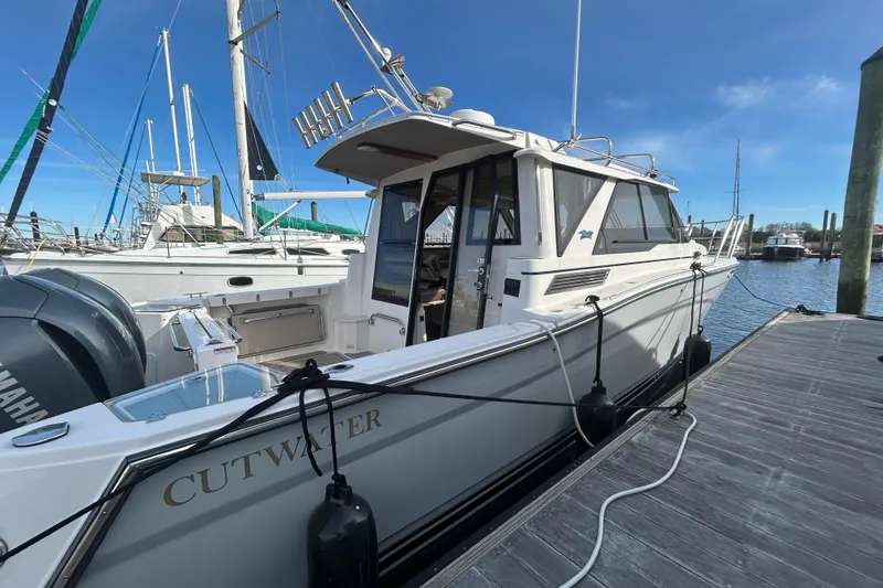 Slide: The Image of 2024 Cutwater C-288 Coupe docked at marina under clear blue sky. - 1