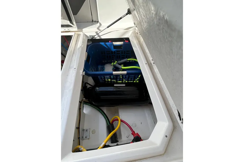 Slide: The Image of 2024 Cutwater C-288 Coupe storage compartment with organized cables and equipment. - 10