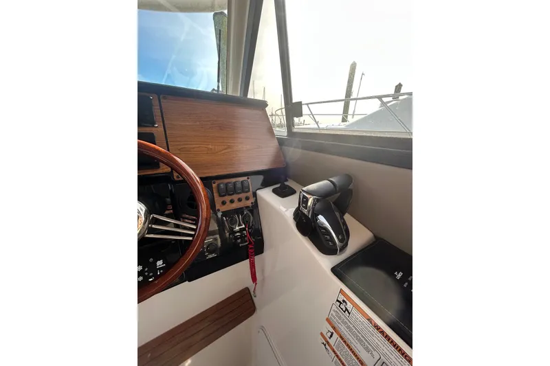 Slide: The Image of 2024 Cutwater C-288 Coupe helm with wooden dashboard and modern controls. - 18