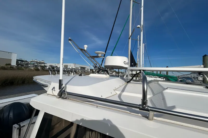 Slide: The Image of 2024 Cutwater C-288 Coupe boat with radar equipment, docked under clear blue sky. - 2