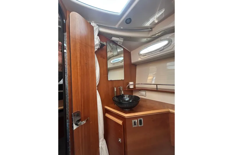 Slide: The Image of 2024 Cutwater C-288 Coupe interior bathroom with wooden cabinetry and modern sink design. - 26