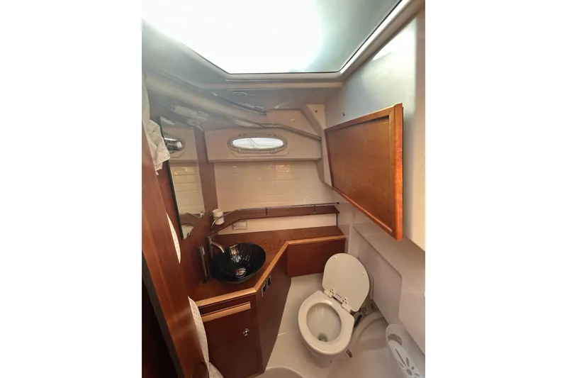 Slide: The Image of 2024 Cutwater C-288 Coupe bathroom with wooden accents and modern fixtures. - 27