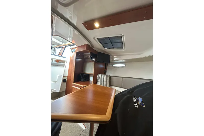 Slide: The Image of 2024 Cutwater C-288 Coupe interior with wooden table, seating, and overhead lighting. - 29