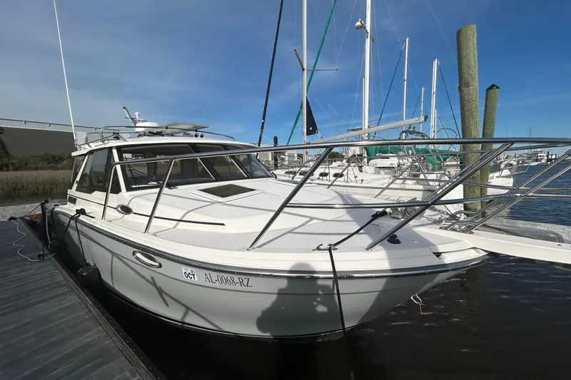 Slide: The Image of 2024 Cutwater C-288 Coupe boat docked at marina under clear blue sky. - 3