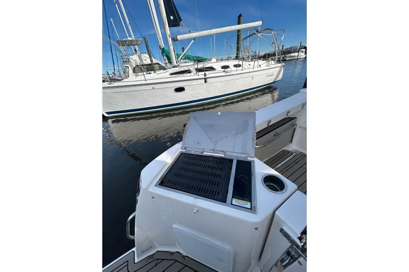 Slide: The Image of 2024 Cutwater C-288 Coupe with outdoor grill, docked near sailboat. - 34