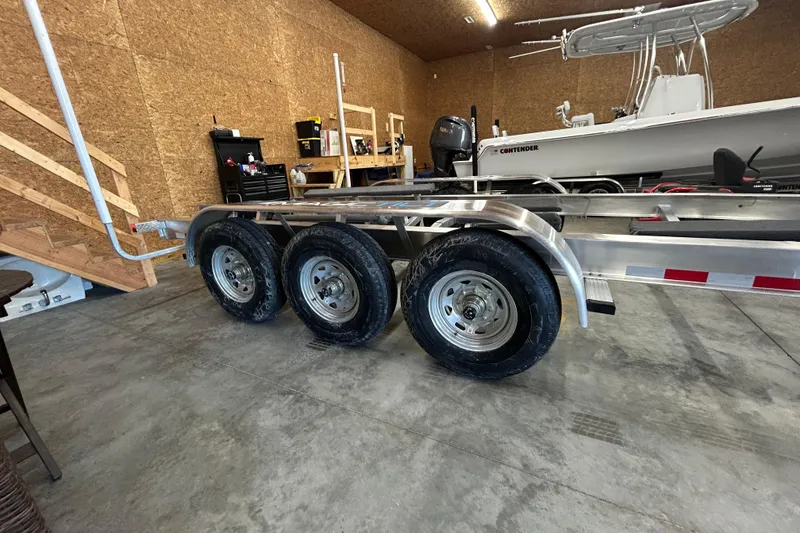 Slide: The Image of Trailer with triple axles in a garage, next to a boat. - 38