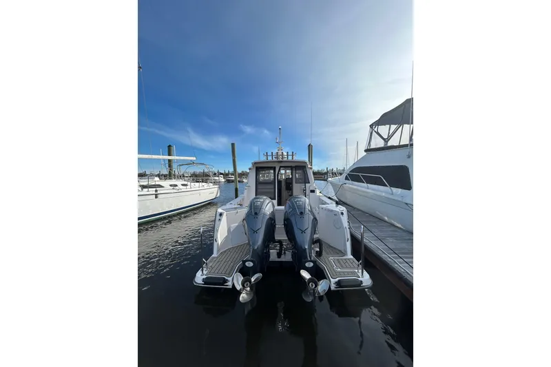 Slide: The Image of 2024 Cutwater C-288 Coupe docked, showcasing dual outboard motors and sleek design. - 5