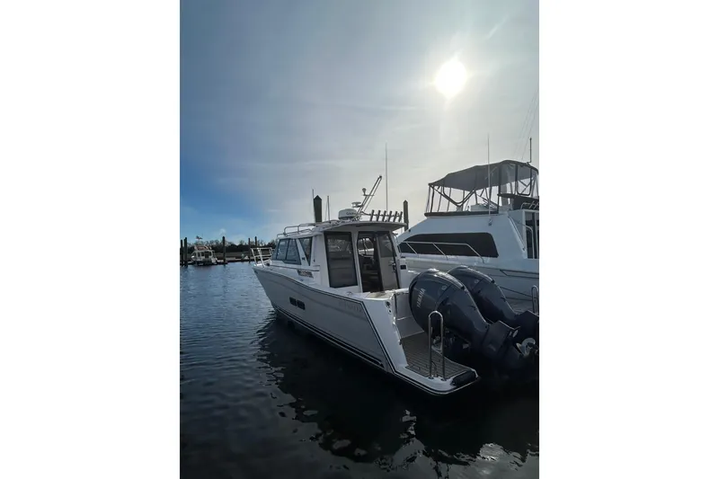 Slide: The Image of 2024 Cutwater C-288 Coupe boat docked in marina under bright sun. - 6