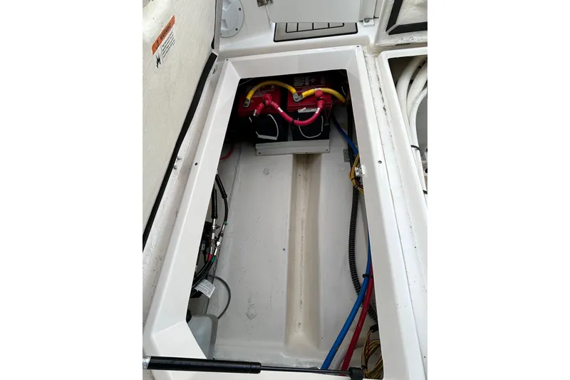 Slide: The Image of 2024 Cutwater C-288 Coupe battery compartment with wiring and storage space. - 9
