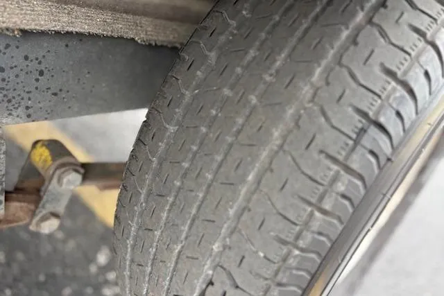 Slide: The Image of Worn tire on a 2016 Nitro Z20 vehicle, showing tread wear and suspension components. - 26