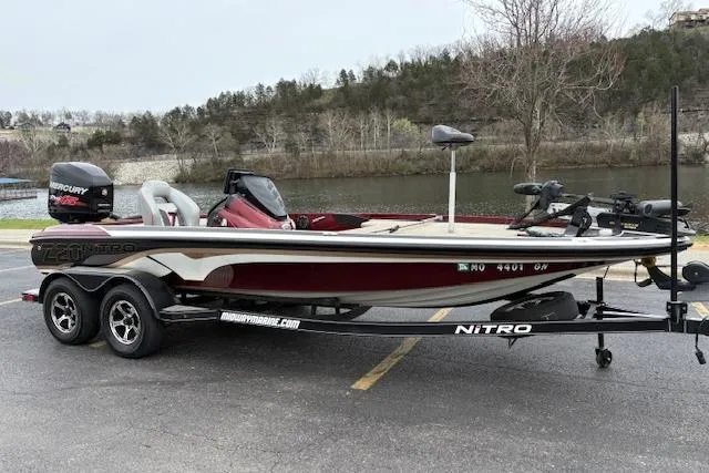 Slide: The Image of 2016 Nitro Z20 boat on trailer by a lake, featuring a Mercury engine. - 3