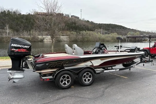 Slide: The Image of 2016 Nitro Z20 boat with Mercury Pro XS engine, parked by a scenic riverside. - 5