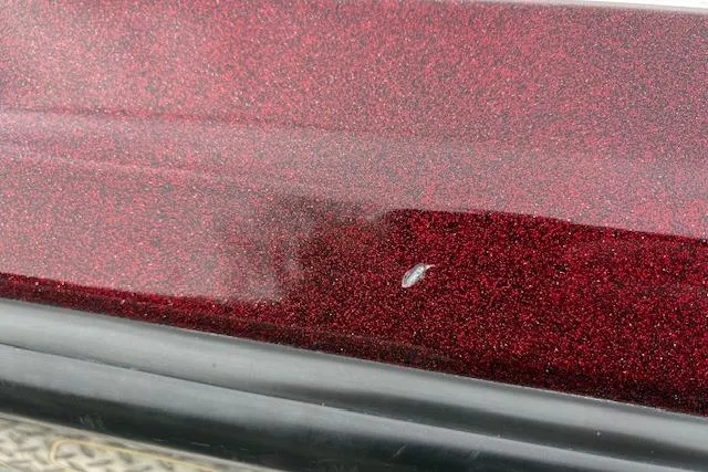 Slide: The Image of Close-up of a 2016 Nitro Z20 with metallic red paint and a small surface scratch. - 56