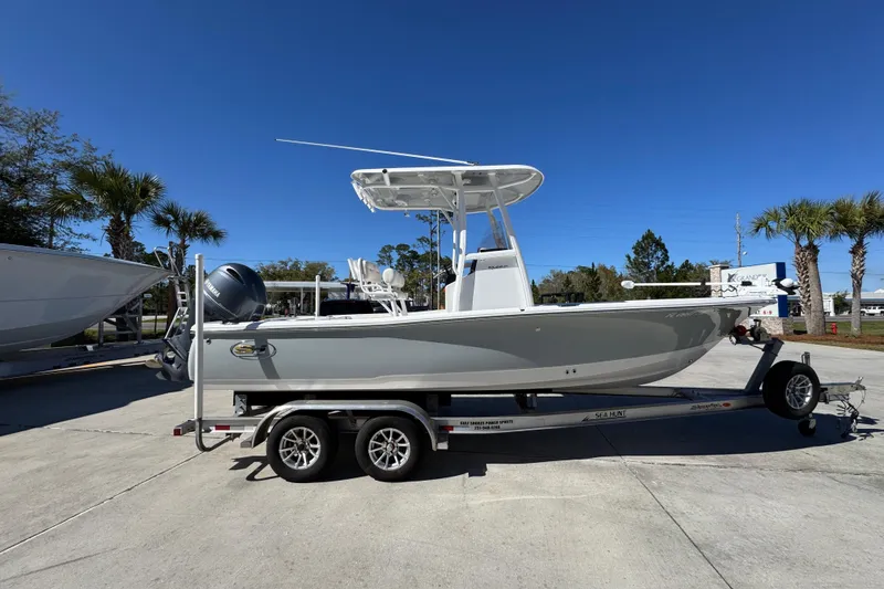 Slide: The Image of 2023 Sea Hunt BX 22 BR boat on trailer, parked outdoors under clear blue sky. - 10