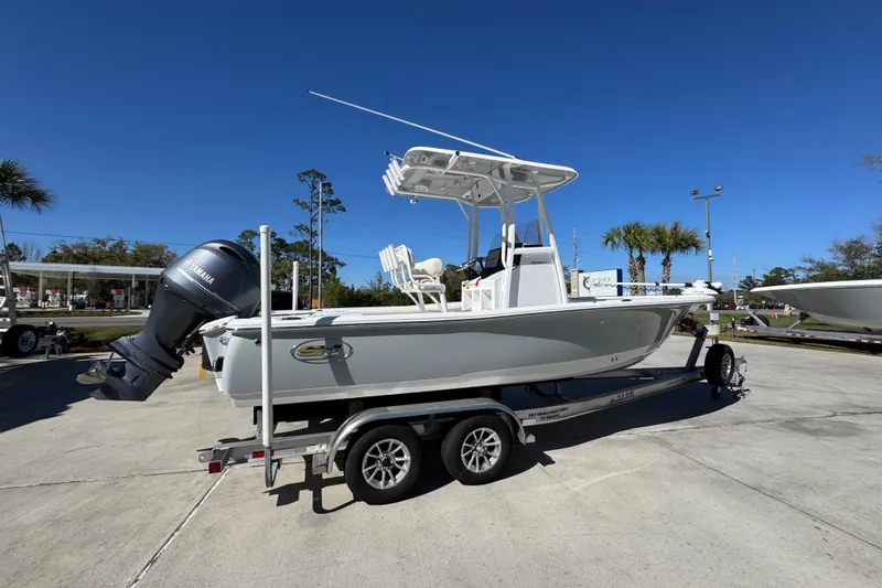 Slide: The Image of 2023 Sea Hunt BX 22 BR boat on trailer, parked outdoors under clear blue sky. - 11