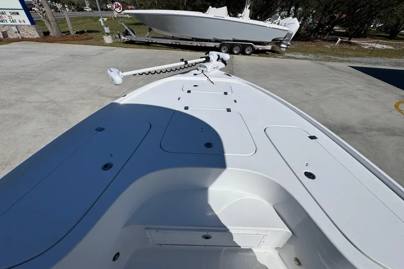 Slide: The Image of 2023 Sea Hunt BX 22 BR boat deck with trolling motor, parked on concrete. - 18