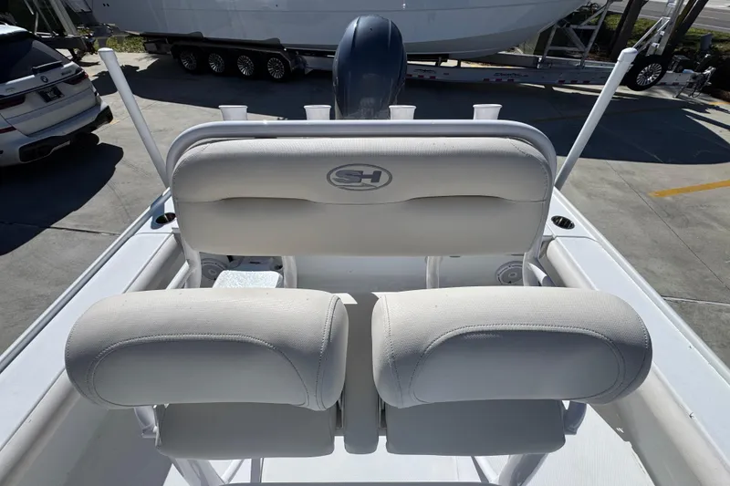 Slide: The Image of 2023 Sea Hunt BX 22 BR boat seating with white upholstery, parked on a trailer. - 27