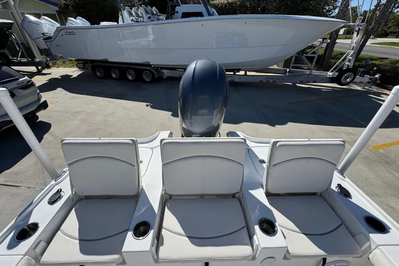 Slide: The Image of 2023 Sea Hunt BX 22 BR boat with three rear seats and motor, parked on trailer. - 37