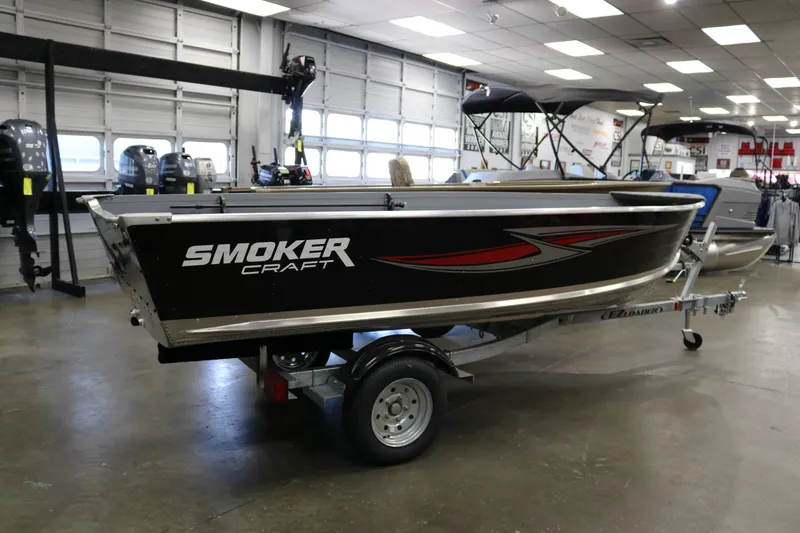 Slide: The Image of 2025 Smoker Craft Big Fisherman 14 boat displayed indoors on a trailer. - 3