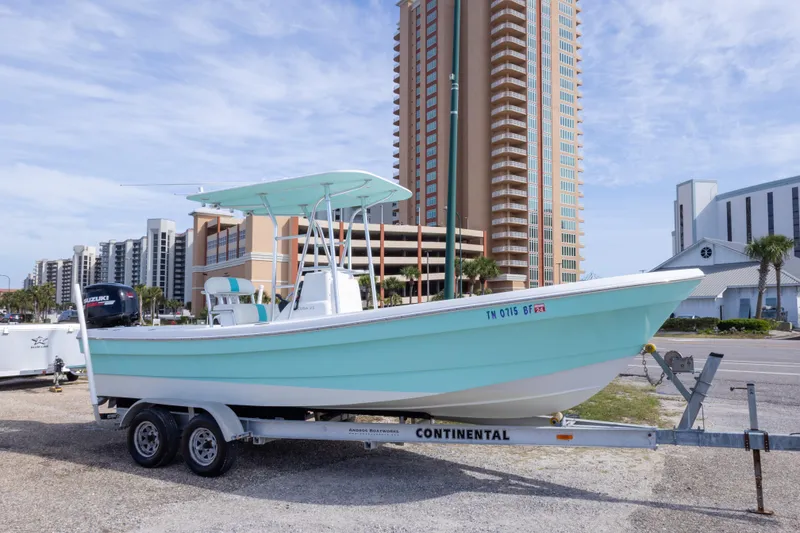 The Image of 2007 Andros Cuda 23 boat on trailer, parked near tall buildings under a clear sky. - 0