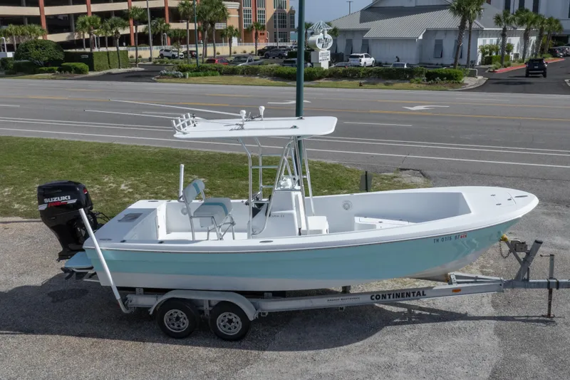 Slide: The Image of 2007 Andros Cuda 23 boat on trailer with Suzuki outboard motor, parked near road. - 12