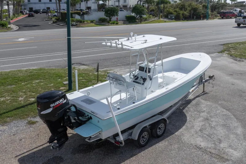 Slide: The Image of 2007 Andros Cuda 23 boat on trailer with Suzuki outboard motor, parked near road. - 13