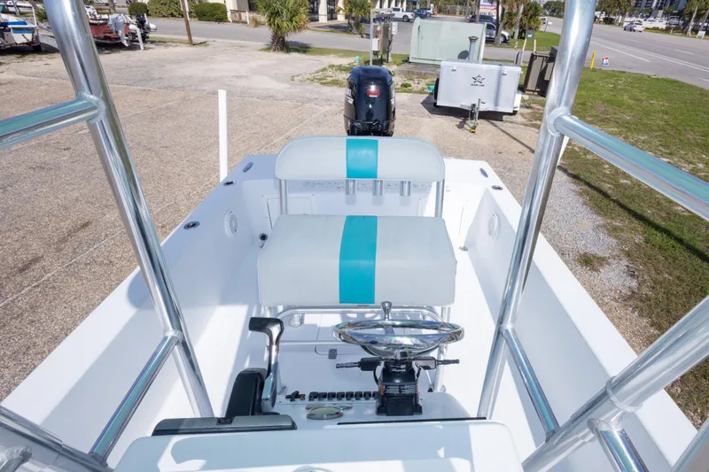 Slide: The Image of 2007 Andros Cuda 23 boat interior with steering wheel and seating, parked outdoors. - 23