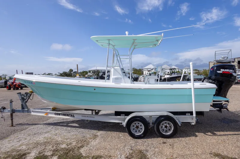 Slide: The Image of 2007 Andros Cuda 23 boat on trailer, light blue hull, Suzuki engine, outdoor setting. - 8