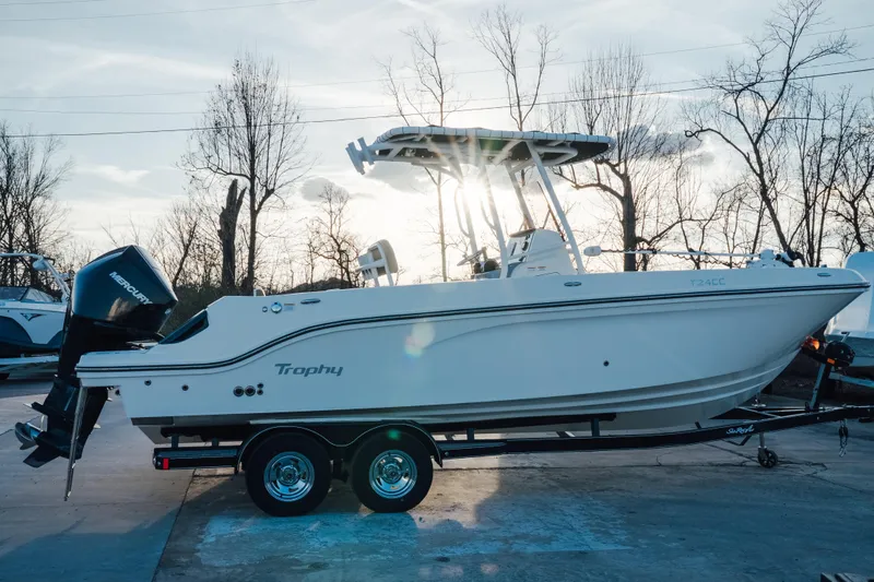 The Image of 2023 Bayliner Trophy T24CC boat on trailer, side view, with Mercury engine. - 0