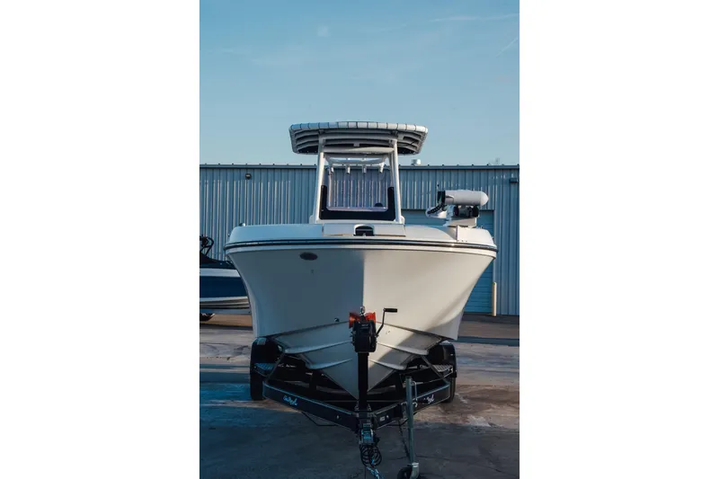 Slide: The Image of 2023 Bayliner Trophy T24CC boat on trailer, parked outdoors. - 2