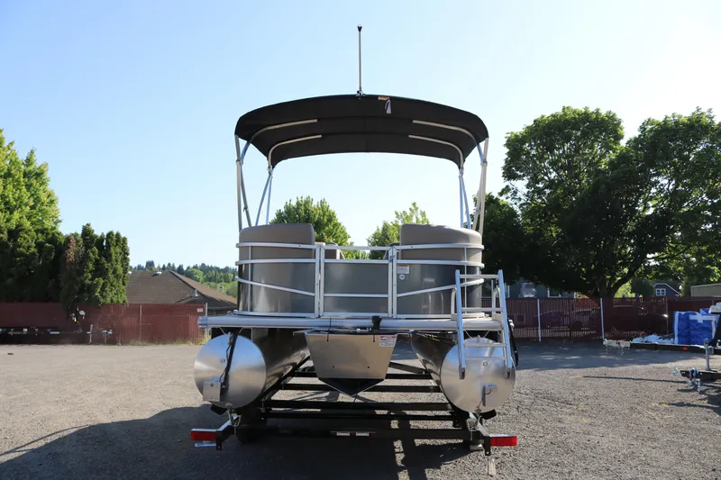 Slide: The Image of 2025 SunChaser Vista 18 Fish pontoon boat on trailer, parked outdoors. - 19