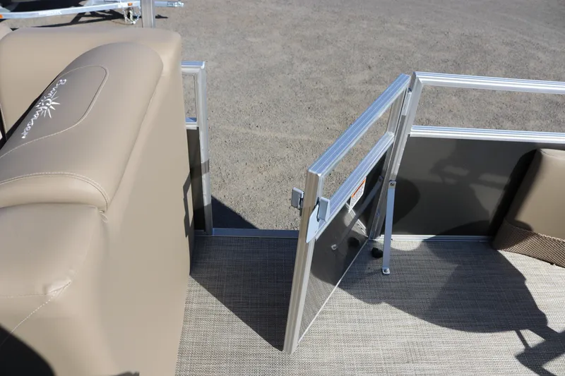 Slide: The Image of SunChaser Vista 18 Fish 2025 pontoon boat interior with open gate and beige seating. - 9