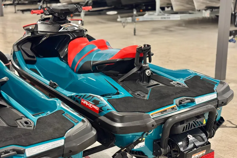 Slide: The Image of 2018 Sea-Doo Wake Pro 230 jet ski with vibrant blue and red design in showroom. - 9
