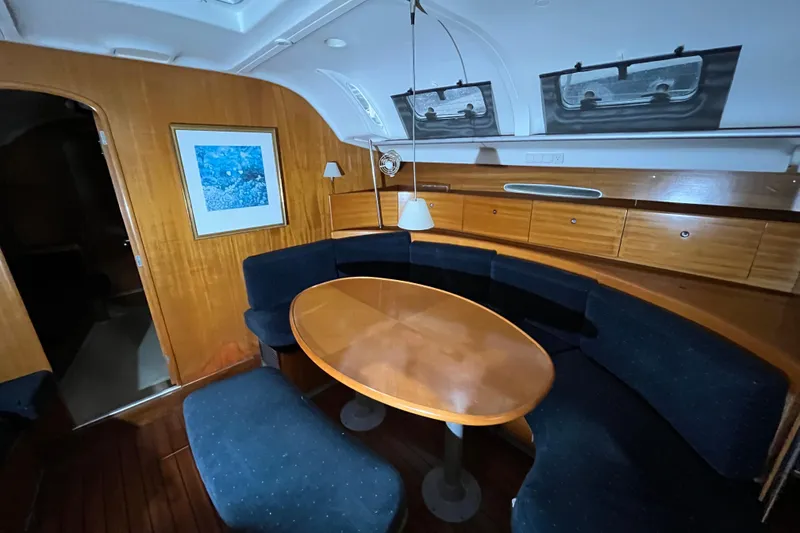 Slide: The Image of Cozy interior of 1999 Beneteau First 42s7 yacht with wooden dining area and blue seating. - 10