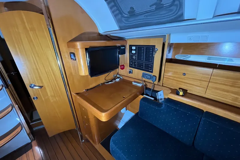 Slide: The Image of Interior of 1999 Beneteau First 42s7 yacht with navigation station and wooden cabinetry. - 12
