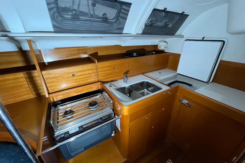 Slide: The Image of Galley kitchen in 1999 Beneteau First 42s7 sailboat with stove, sink, and storage. - 13