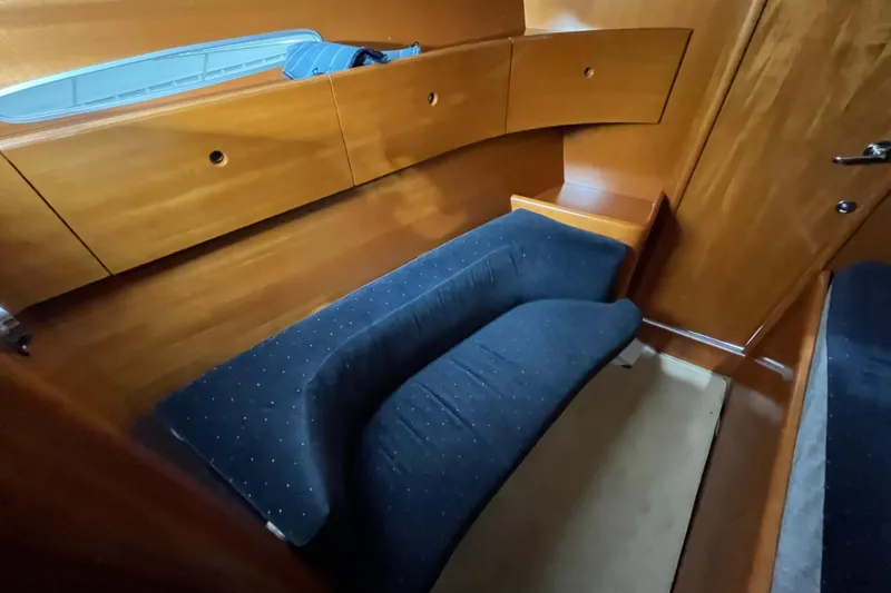 Slide: The Image of Interior cabin of 1999 Beneteau First 42s7 yacht with wooden finish and cushioned seating. - 17