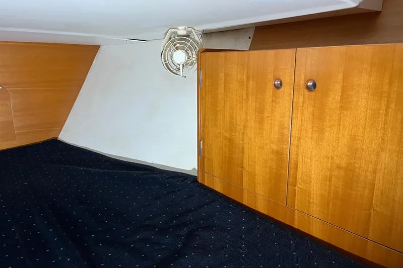 Slide: The Image of Interior cabin of 1999 Beneteau First 42s7 with wooden cabinets and a small fan. - 19