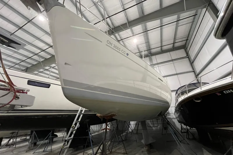Slide: The Image of 1999 Beneteau First 42s7 sailboat in storage, viewed from below in a warehouse. - 2