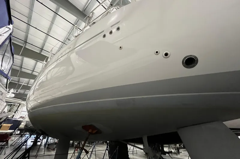 Slide: The Image of 1999 Beneteau First 42s7 sailboat in dry dock, showcasing sleek hull design. - 3