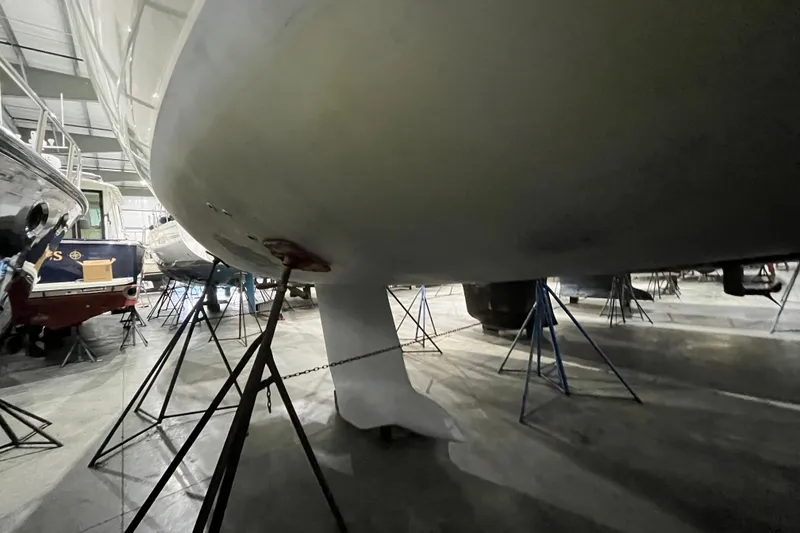 Slide: The Image of 1999 Beneteau First 42s7 sailboat in dry dock, supported by stands in a storage facility. - 6