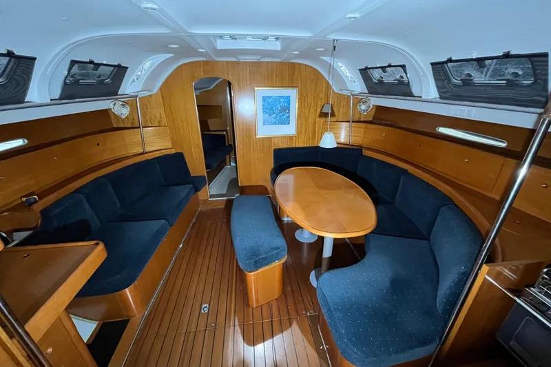 Slide: The Image of Interior of 1999 Beneteau First 42s7 yacht with wooden finish and blue seating. - 8