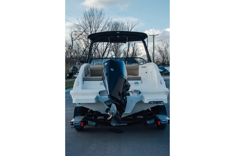 Slide: The Image of 2023 Bayliner DX 2200 boat, rear view with outboard motor, parked outdoors. - 3