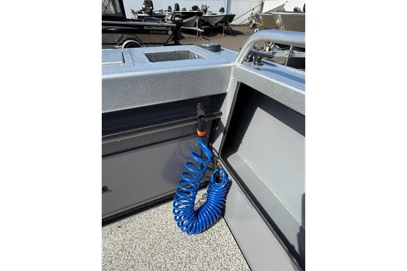 Slide: The Image of 2025 Alumaweld Stryker X202 boat interior with blue coiled hose and storage compartment. - 12
