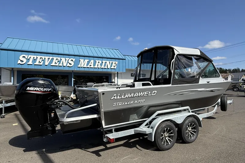 Slide: The Image of 2025 Alumaweld Stryker X202 boat at Stevens Marine dealership, featuring Mercury outboard motor. - 2