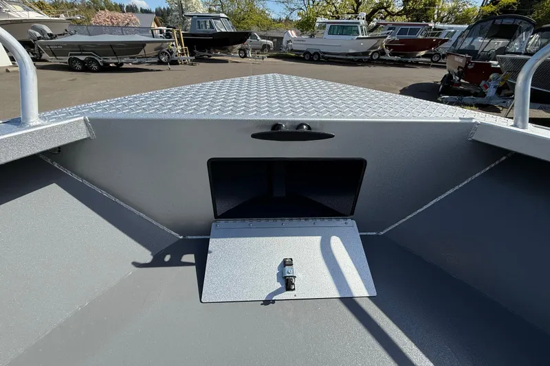 Slide: The Image of 2025 Alumaweld Stryker X202 boat interior with storage compartment, parked among other boats. - 29
