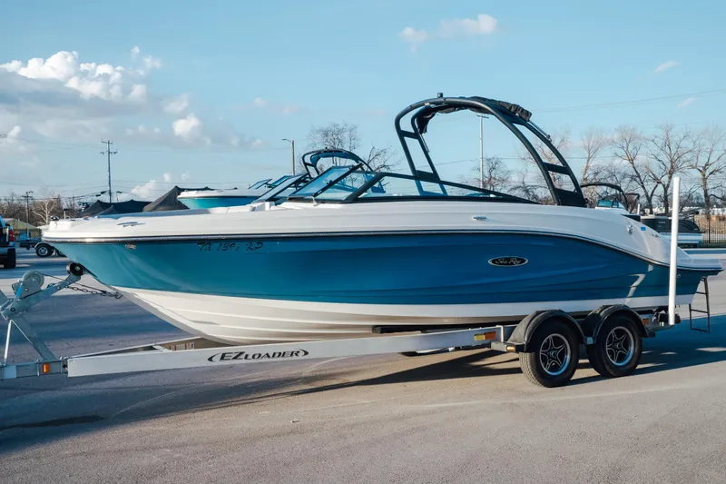 The Image of 2023 Sea Ray SPX 230 boat on trailer, parked outdoors under clear sky. - 0