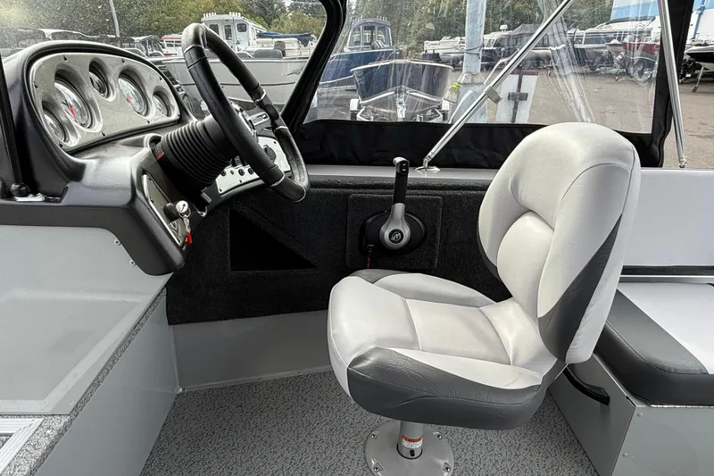 Slide: The Image of Interior of 2025 Smoker Craft Osprey 162 boat, featuring steering wheel and cushioned seat. - 10