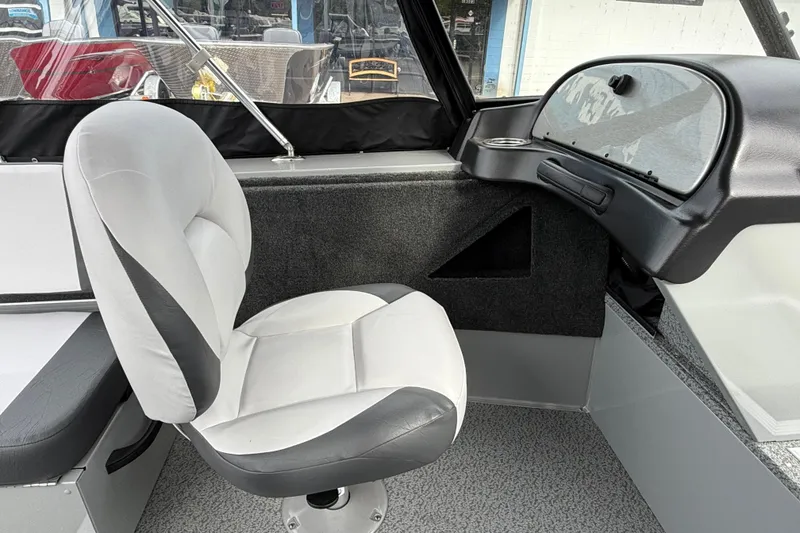 Slide: The Image of Interior of 2025 Smoker Craft Osprey 162 boat with cushioned seating and dashboard. - 13