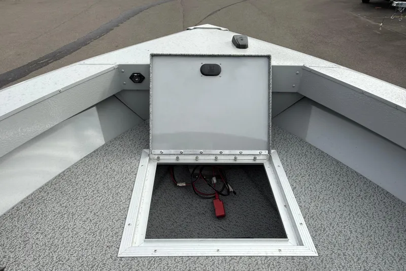 Slide: The Image of 2025 Smoker Craft Osprey 162 boat storage compartment with open hatch and visible wiring. - 23